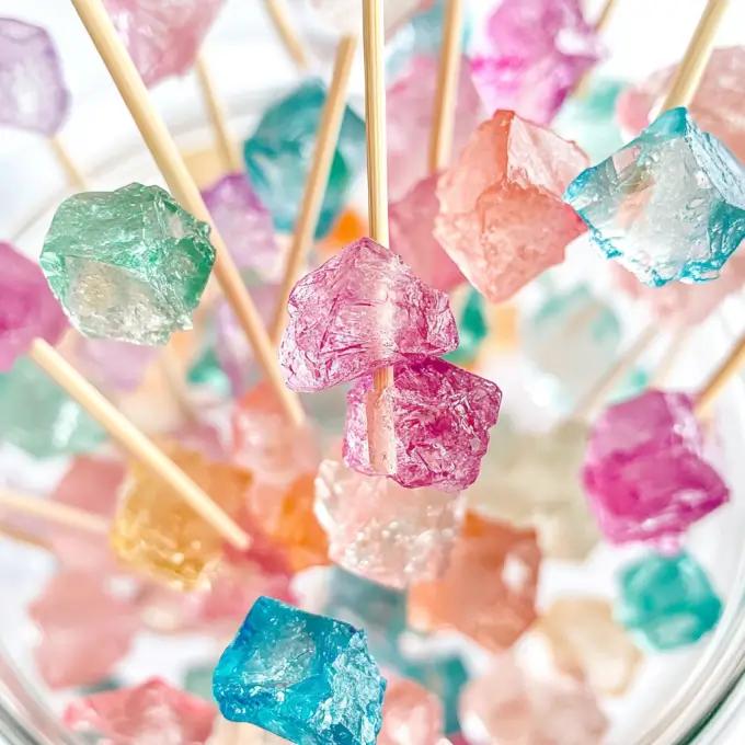 Colorful Crystal Candy Recipe hanging in a jar, showcasing vibrant sugar crystals.
