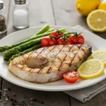 Grilled swordfish recipe steak with asparagus and tomatoes.