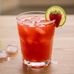 strawberry margarita recipe in a glass with lime and strawberry garnish
