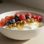 Greek yogurt recipes topped with honey, fresh berries, and granola.